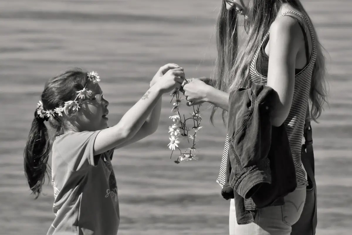 Seorang anak perempuan memberikan bunga kepada ibunya